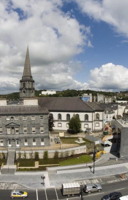 "Bishop's Palace in Viking Triangle, Waterford City with a view of a historic building, greenery, and a path in the foreground."