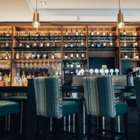 The image features a modern hotel lobby with shiny marble floors, plush seating, decorative plants, and ambient lighting, creating a welcoming and luxurious atmosphere.