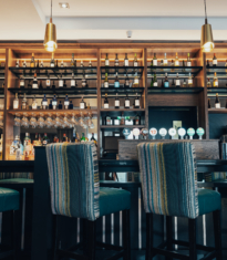 The image features a modern hotel lobby with shiny marble floors, plush seating, decorative plants, and ambient lighting, creating a welcoming and luxurious atmosphere.